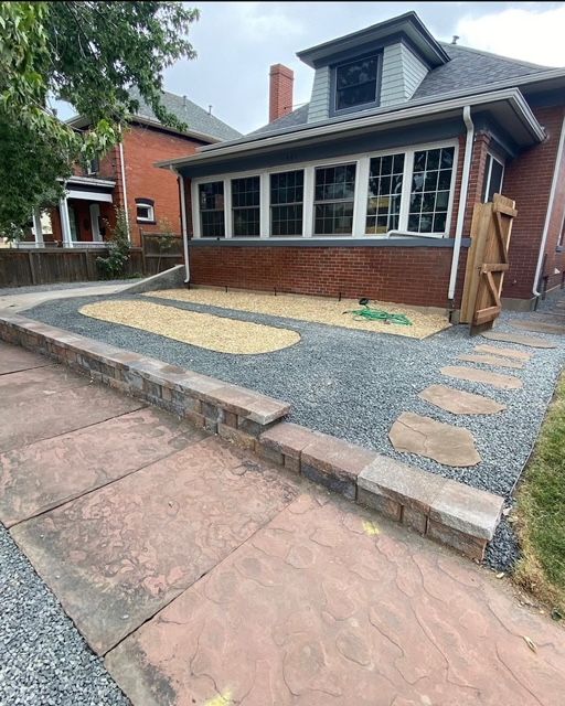 House front with raised brick porch, stone steps, and gravel landscaping; no accessible ramp visible